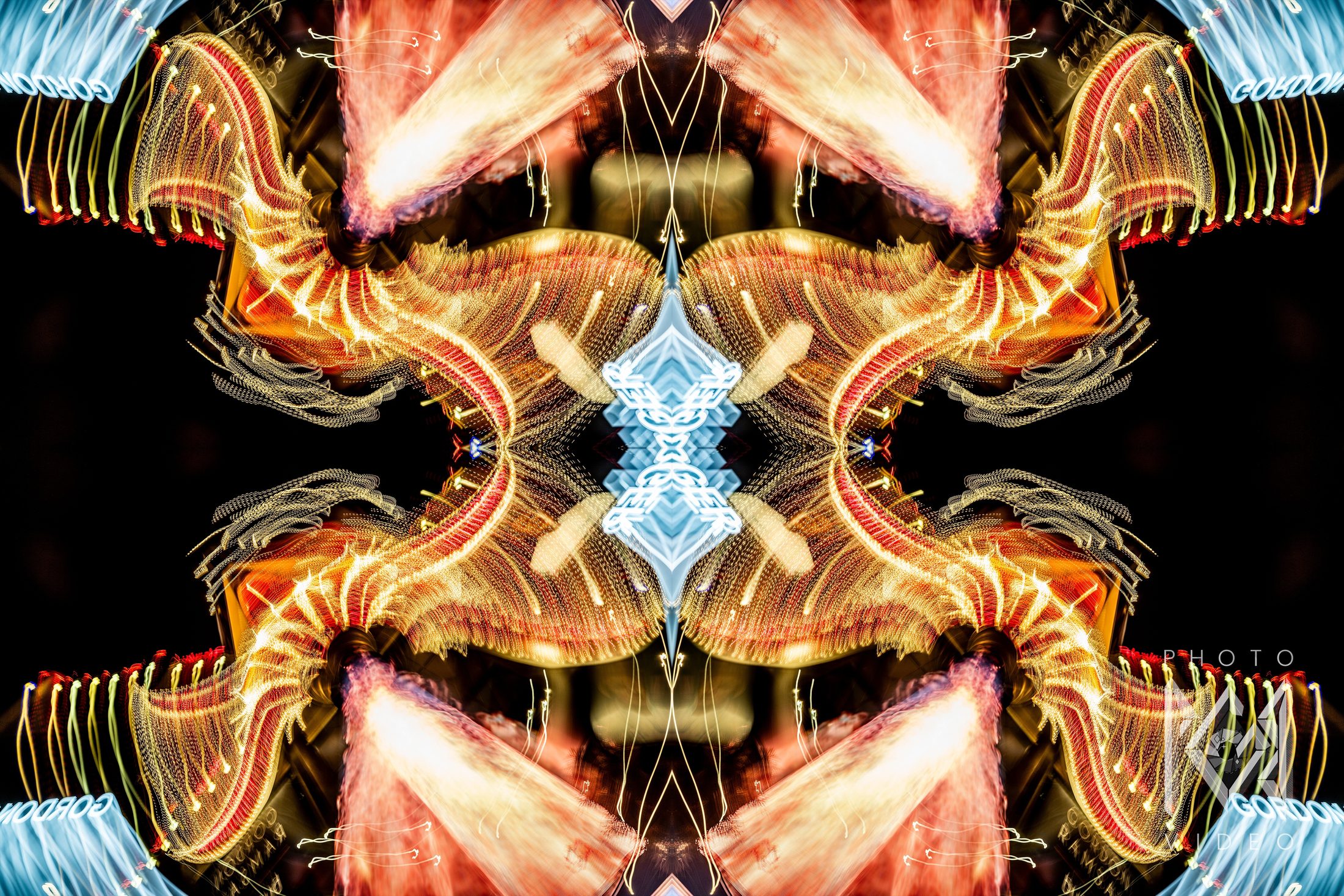 Gold and red light trails from a casino sign mirrored four ways around a pale blue centre
