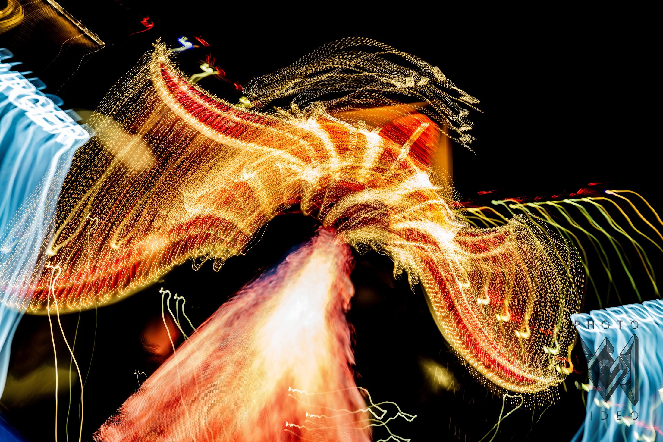 Gold and red casino sign lights drawn into sweeping ribbons by a moving camera, with blue lettering at the edges