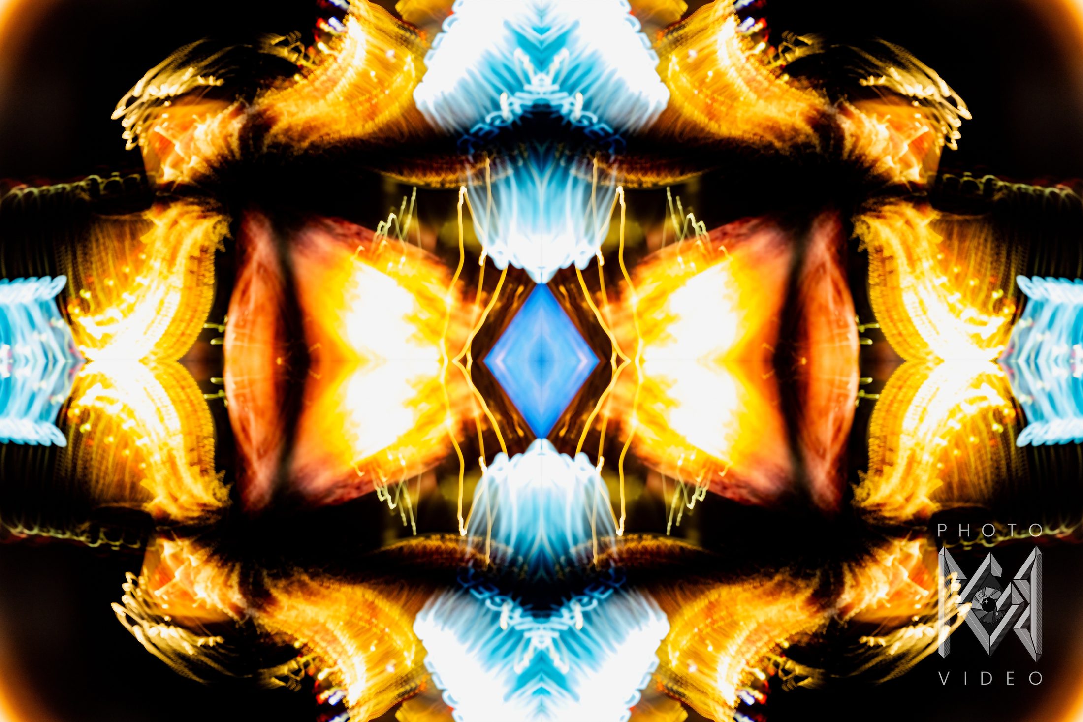 Gold, orange and ice-blue light mirrored four ways around a blue diamond