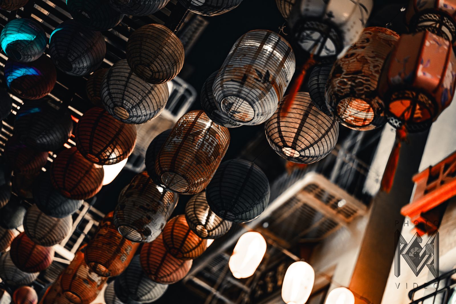 Rows of paper lanterns hanging over a Chinatown street, seen from below