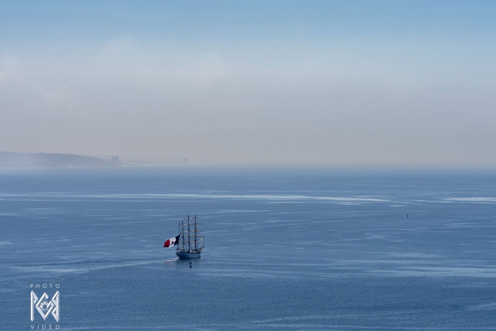 The ship far out on hazy blue water