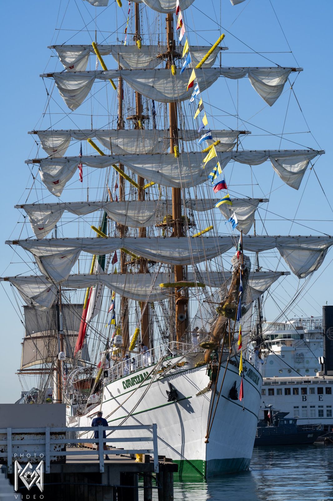 The tall ship moored at the pier with her sails loosed, seen from the bow