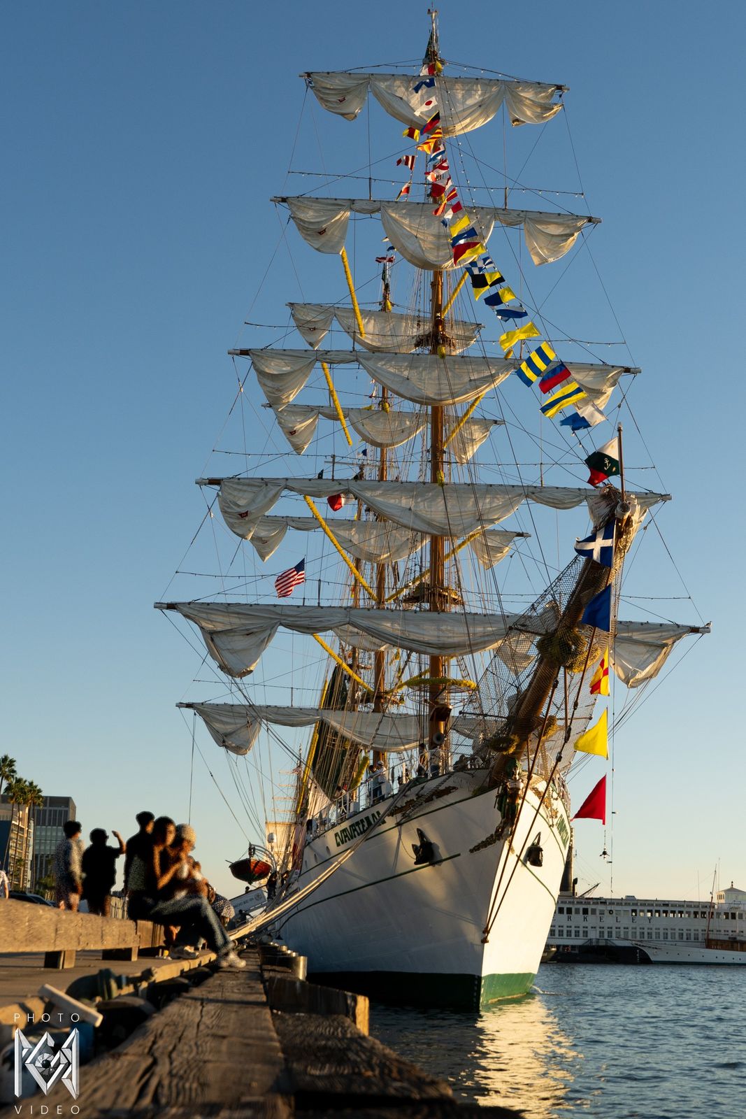 The ship's sails and masts above the pier in warm evening light