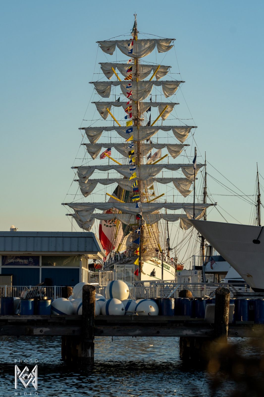 The ship's masts rising above the pier at dusk