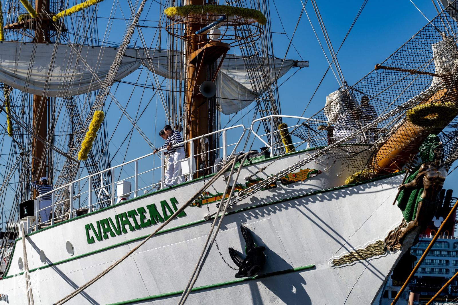 The white hull and green lettering of the ship's name at the bow, with a rope across the frame