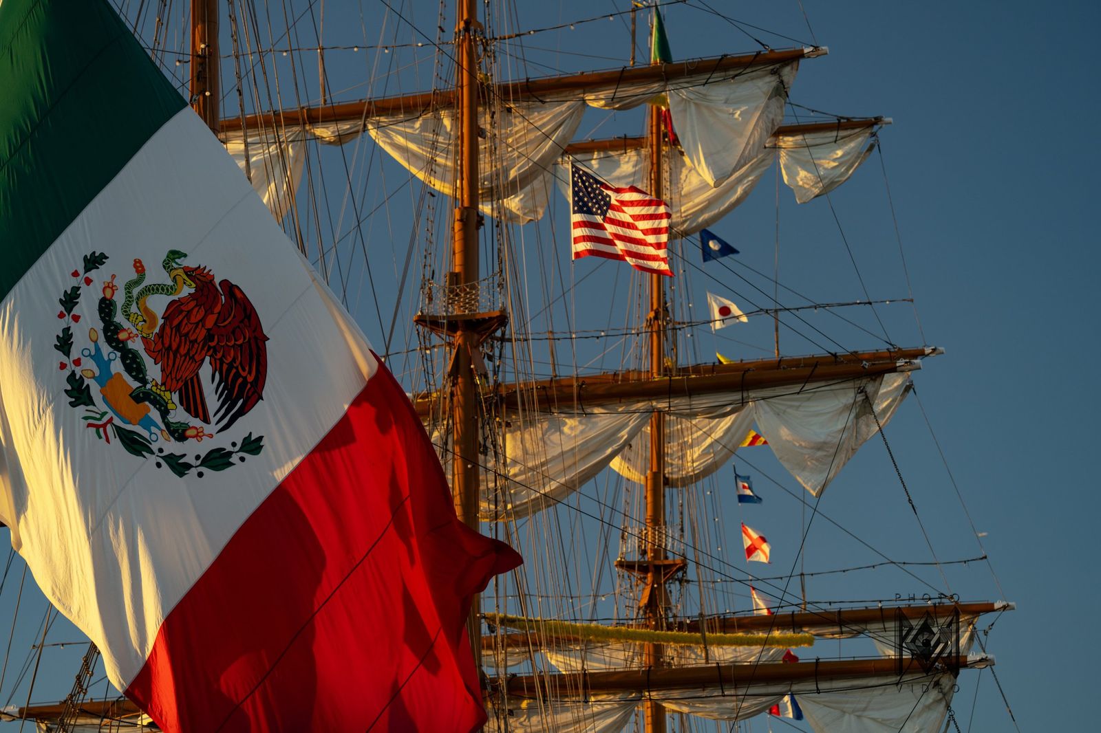 The Mexican and American flags above the yards, against a deep blue sky