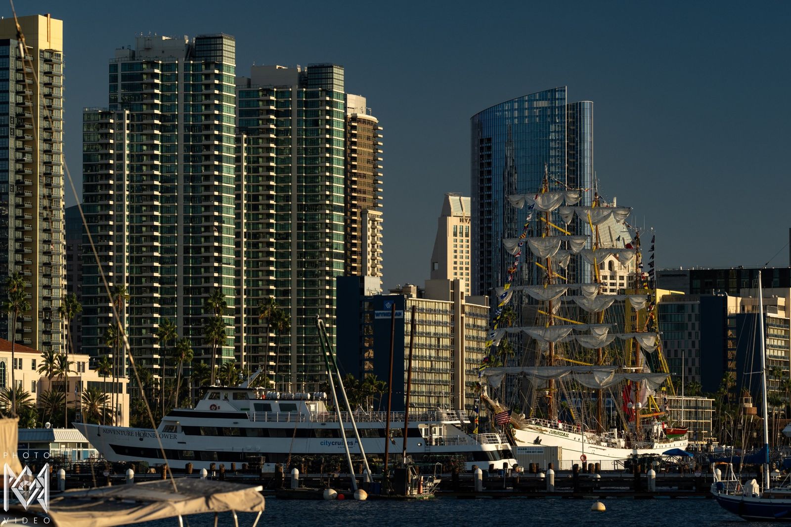The ship's rigging rising among the towers of the city, boats in front