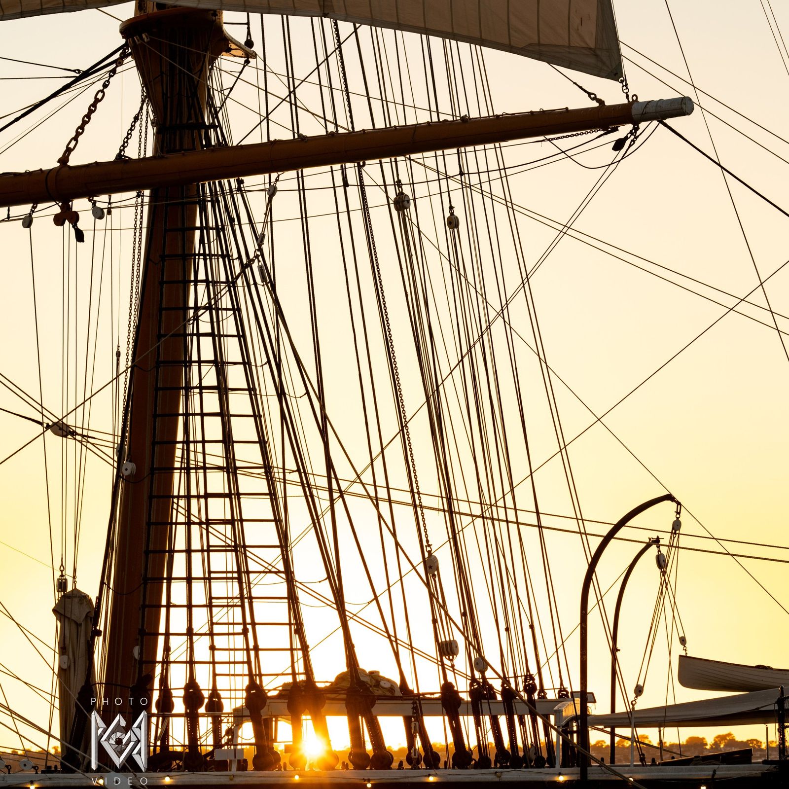 The sun setting through the ship's rigging