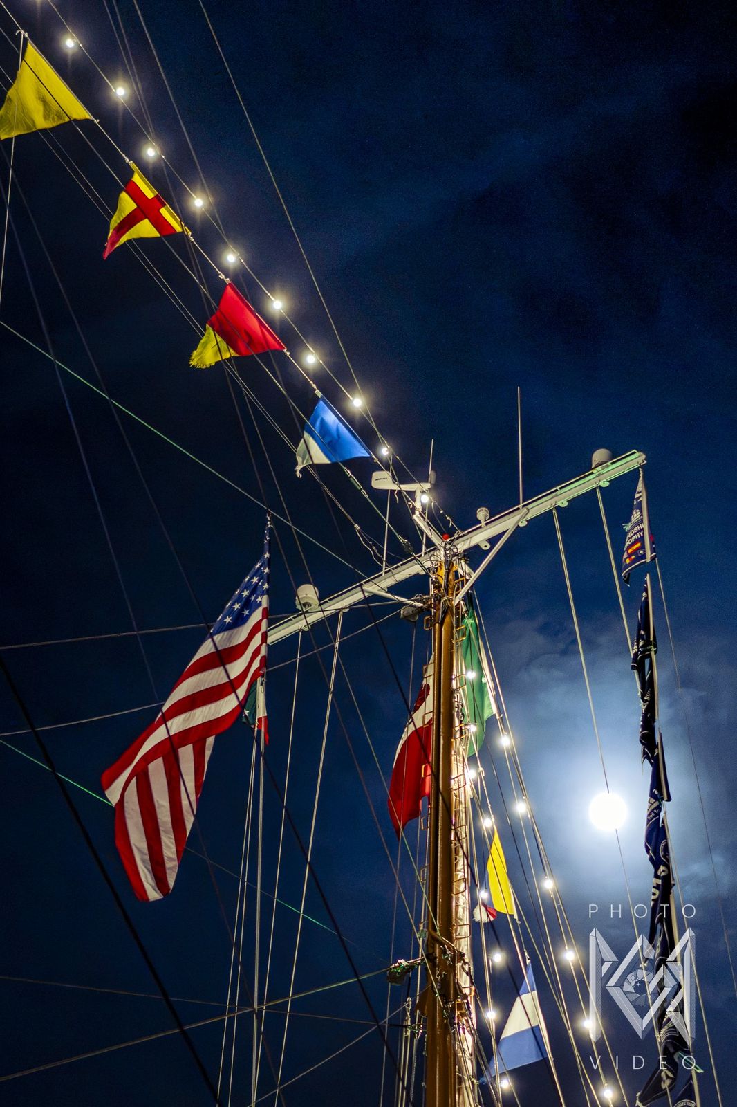 The mast with the American flag and signal flags, a full moon beside it