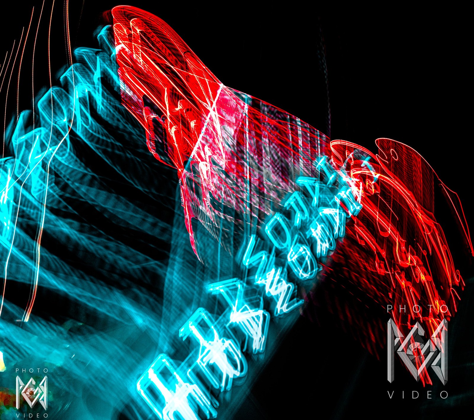 A tilted, zoom-blurred neon motel sign, cyan letters and red swooping light trails radiating across the dark