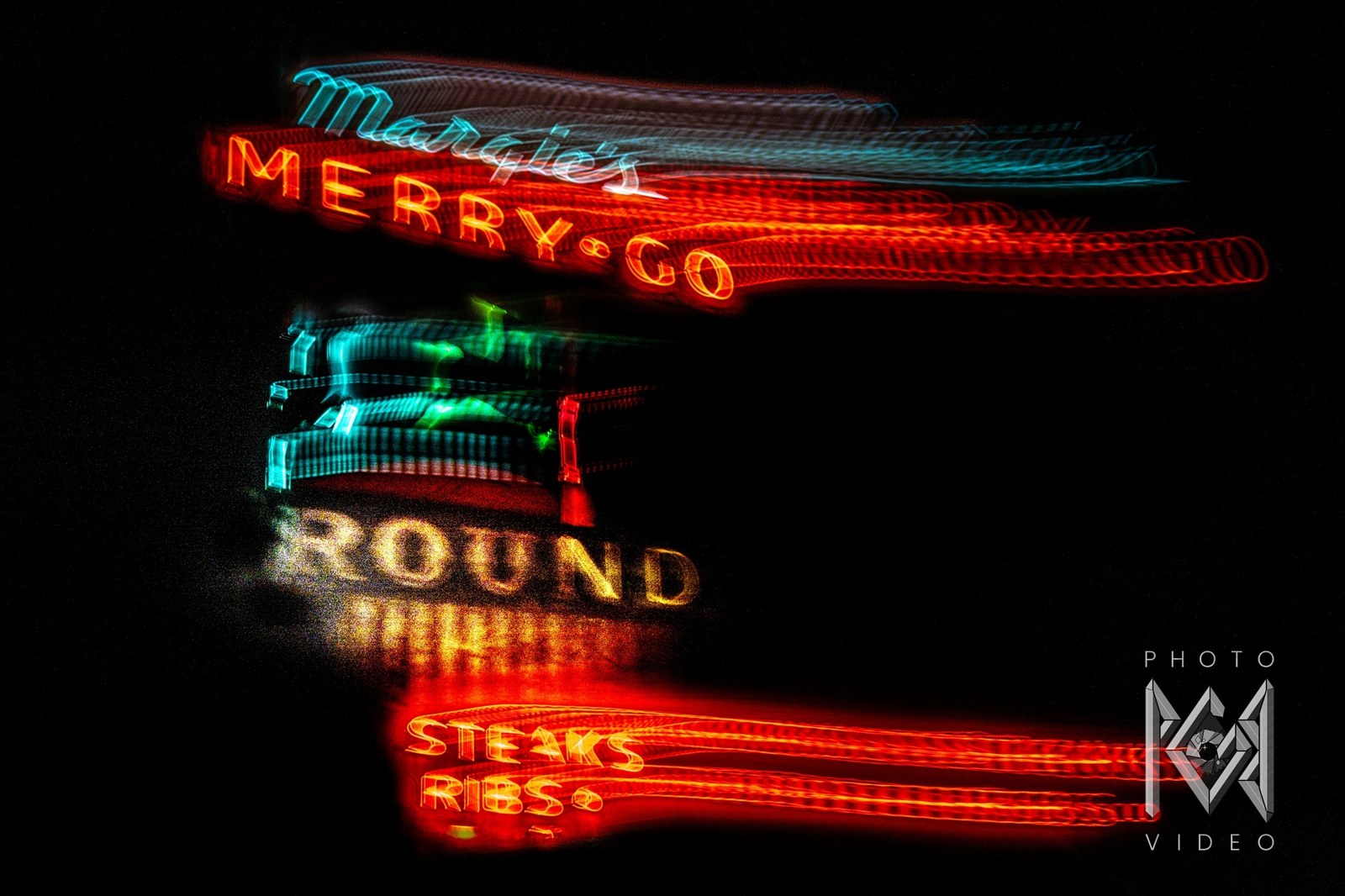 Margie's Merry-Go-Round neon sign streaked sideways by a long exposure, red MERRY-GO lettering above ROUND and a glowing STEAKS RIBS sign